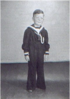 En stolt femåring i matrosdress sydd av portierer.